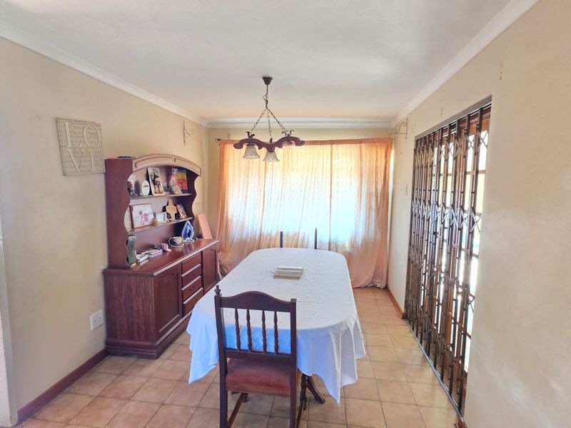 Dining room featuring ceramic tile flooring, coved ceilings, and a sliding security gate leading to the exterior.
