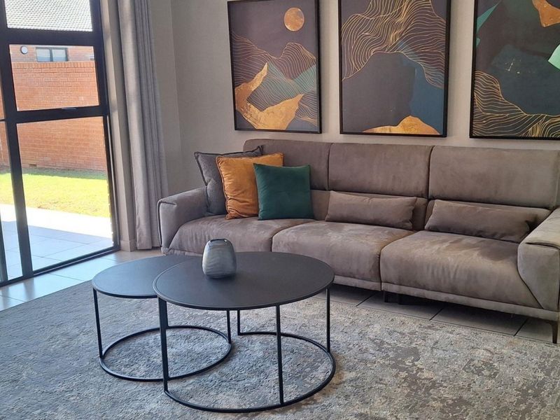 A well-maintained living room featuring large sliding glass doors that provide natural light and direct access to the outdoor patio area.