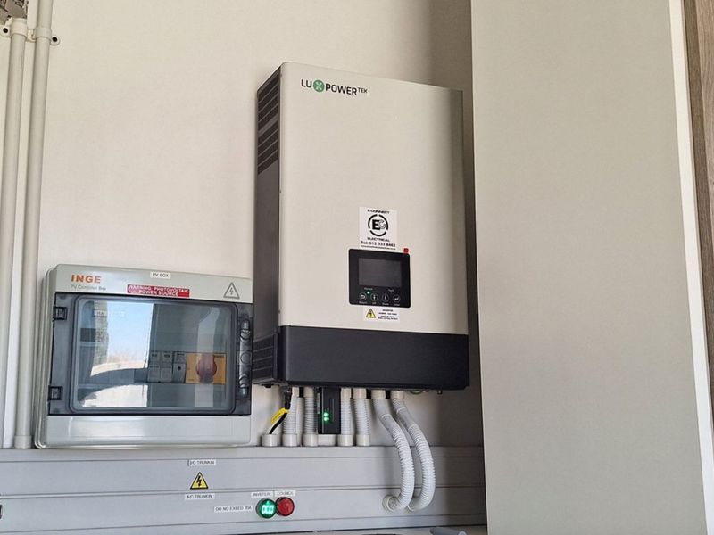 A wall-mounted solar inverter and PV combiner box installation, indicating an integrated renewable energy system for the property.
