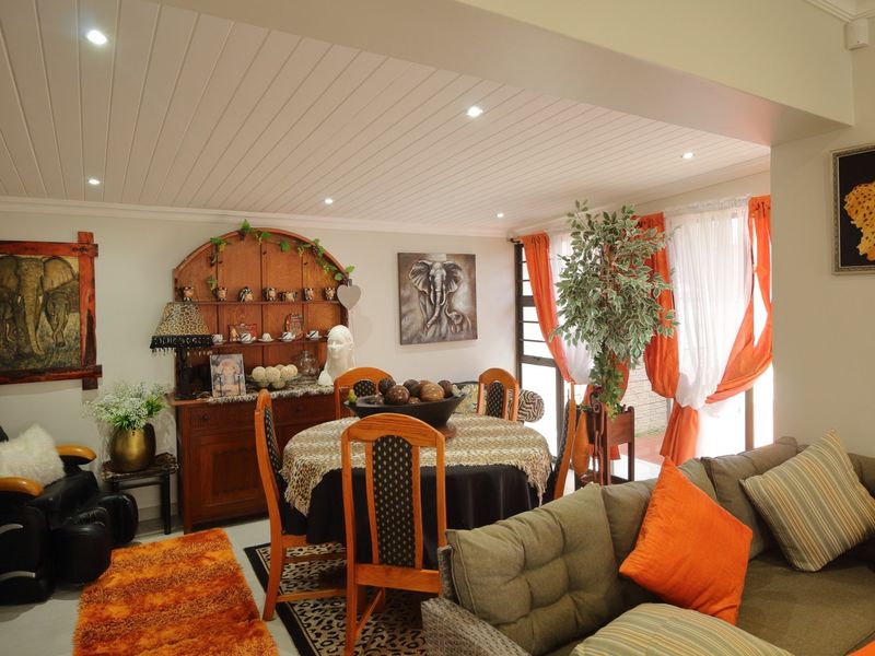 Open-plan living and dining area featuring tiled flooring, recessed downlighting, and a tongue and groove ceiling with access to the outdoor space.