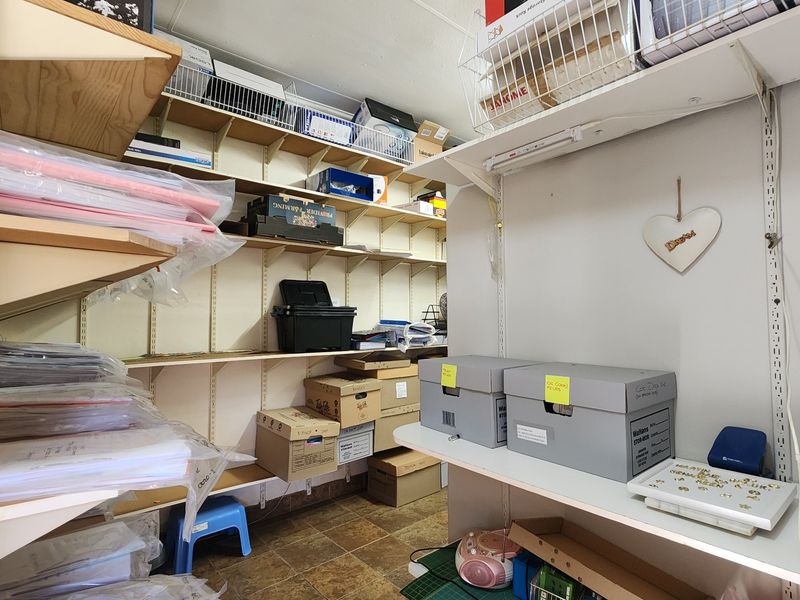 A functional utility or storage room featuring extensive wall-mounted shelving and durable tiled flooring, providing ample space for organization and storage needs.