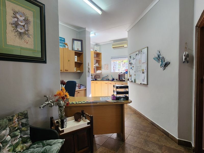 A functional home office space featuring built-in cabinetry, tiled flooring, and an integrated air conditioning unit.