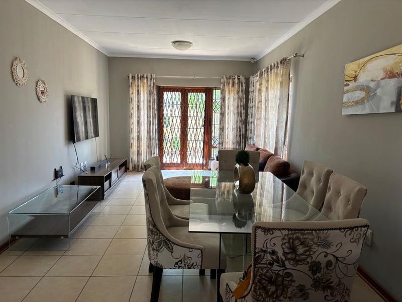 Open plan living and dining area featuring tiled flooring and double glass doors leading to the exterior.