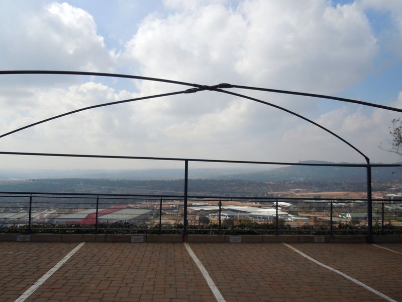 Elevated outdoor parking area featuring a metal frame structure and expansive panoramic views of the surrounding landscape.
