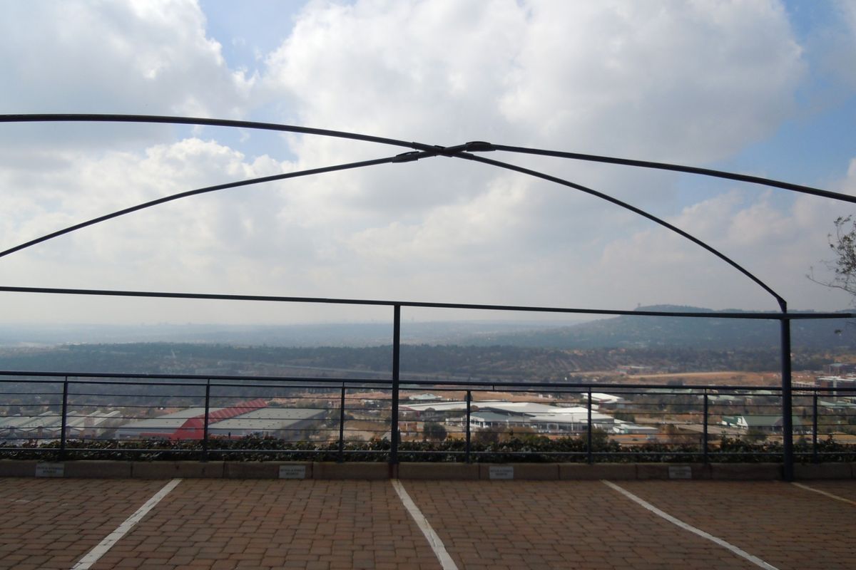 Elevated outdoor parking area featuring a metal frame structure and expansive panoramic views of the surrounding landscape.