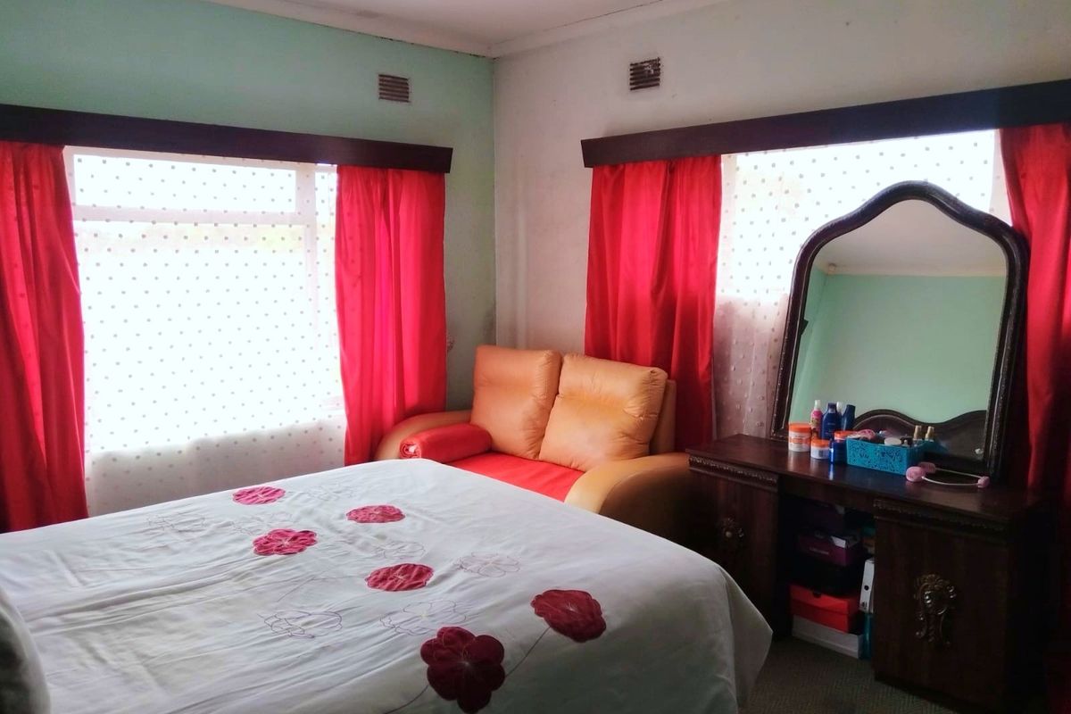 A bedroom featuring dual windows with built-in wall ventilation, requiring cosmetic updates to the wall finishes.