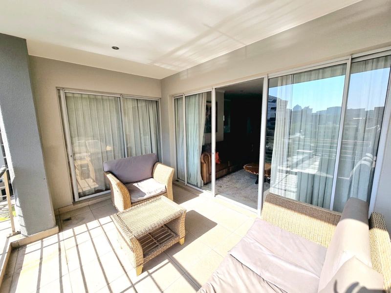 A covered balcony featuring tiled flooring, recessed lighting, and large sliding glass doors providing seamless access to the interior living space.