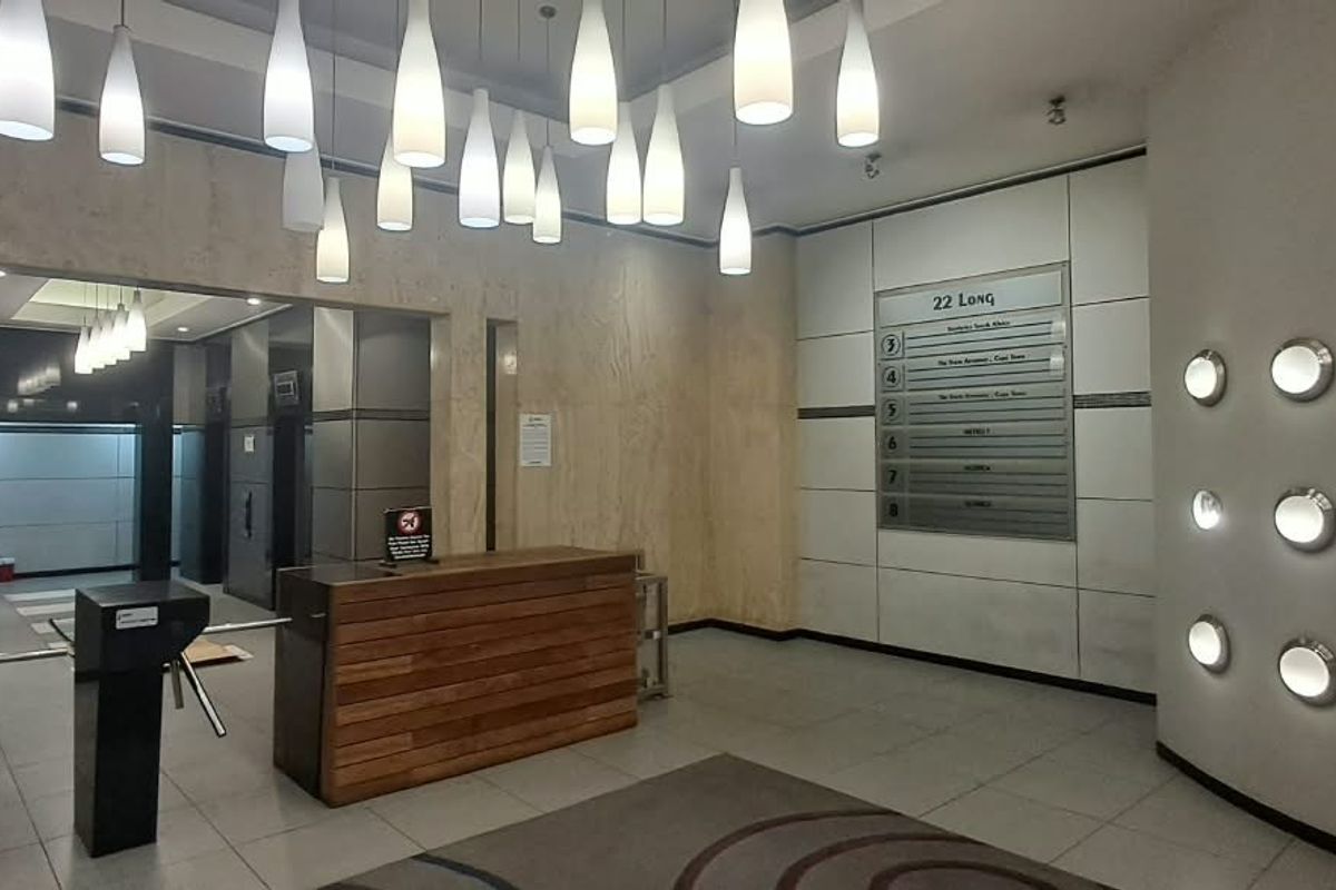 Modern office building lobby featuring a reception desk, security turnstiles, directory board, and elegant marble wall finishes with ambient pendant and recessed lighting.