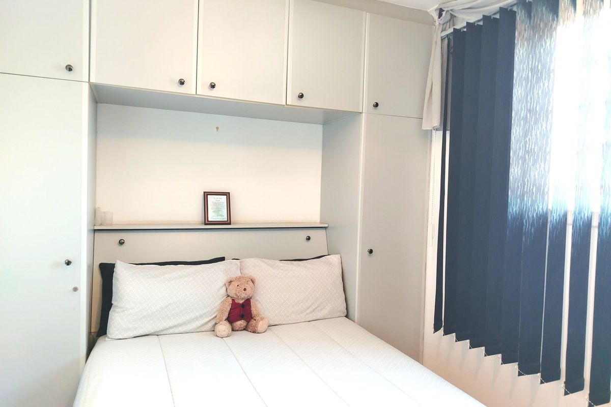 Bedroom featuring extensive built-in cabinetry and overhead storage units, providing ample space for organization and storage.