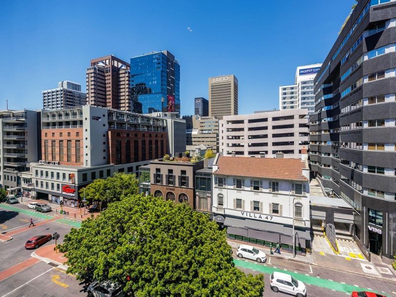 An elevated urban view showcasing the surrounding city skyline, commercial buildings, and street-level infrastructure in a vibrant metropolitan area.