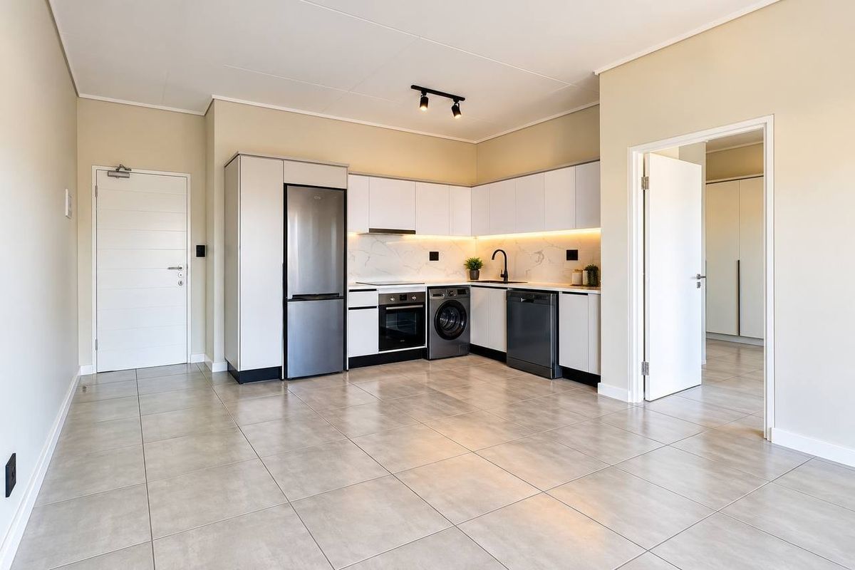 Modern kitchen featuring sleek white cabinetry, stone-look backsplash, integrated appliances, and neutral tiled flooring in an open-plan layout.