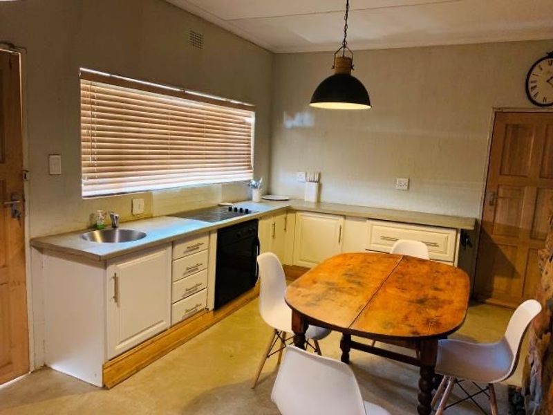 A functional kitchen featuring built-in cabinetry, a hob, an oven, and a sink, with a dining area integrated into the space.