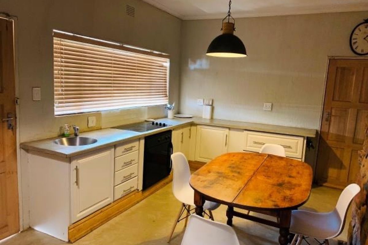 A functional kitchen featuring built-in cabinetry, a hob, an oven, and a sink, with a dining area integrated into the space.