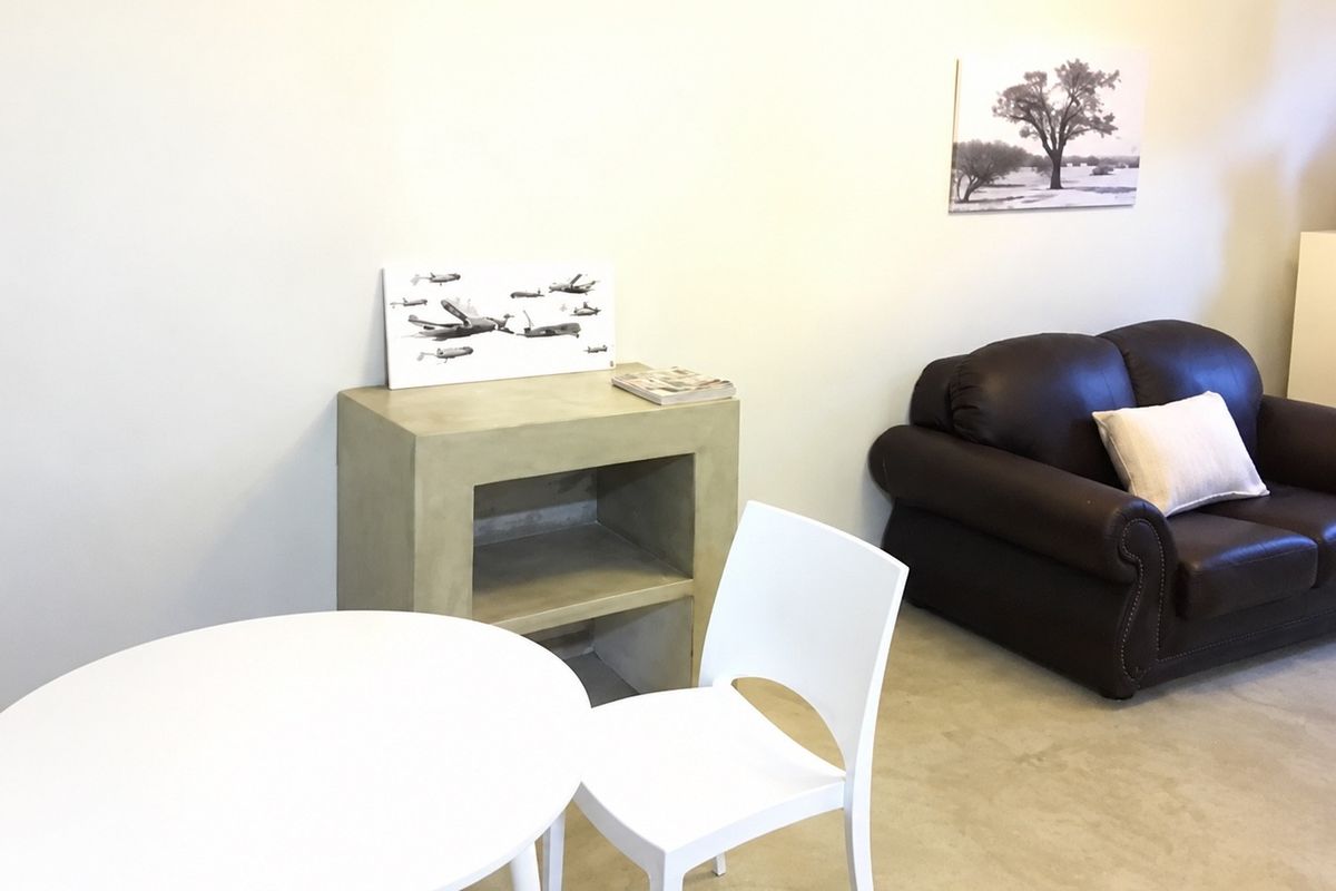 A living area featuring a minimalist concrete console unit and neutral flooring, offering a clean and versatile space for interior design updates.