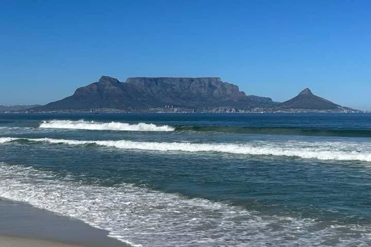 A scenic view of the ocean with Table Mountain visible in the distance.