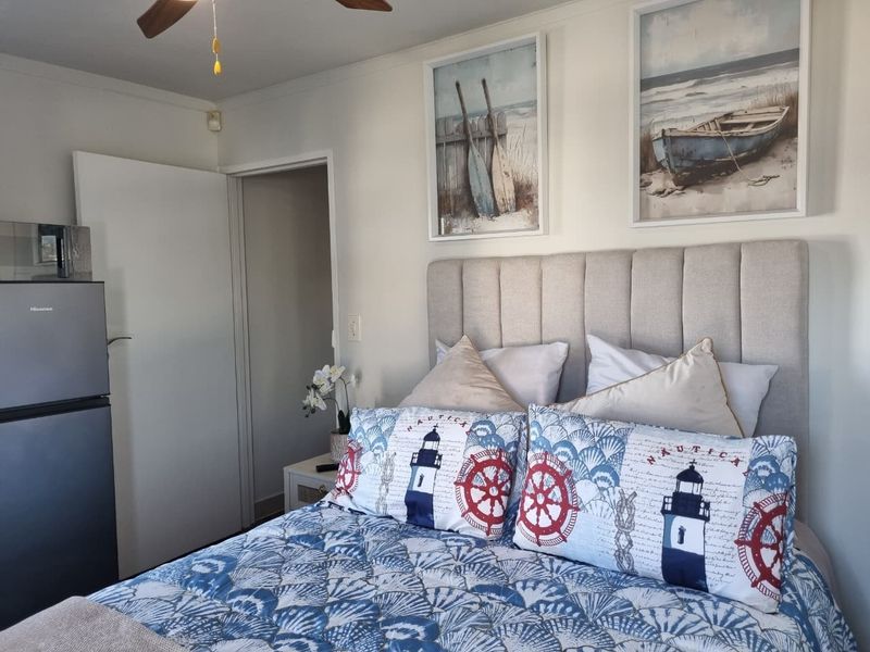 A well-maintained bedroom featuring a ceiling fan and neutral wall finishes, providing a comfortable and functional space.