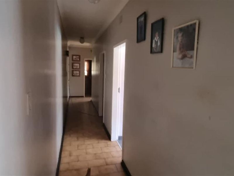 A functional hallway featuring tiled flooring and neutral wall finishes, providing access to various rooms within the home.