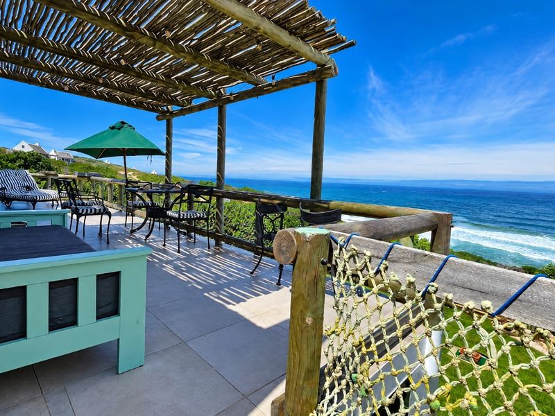Spacious outdoor patio featuring a timber pergola, tiled flooring, and panoramic ocean views, perfect for coastal living and entertaining.