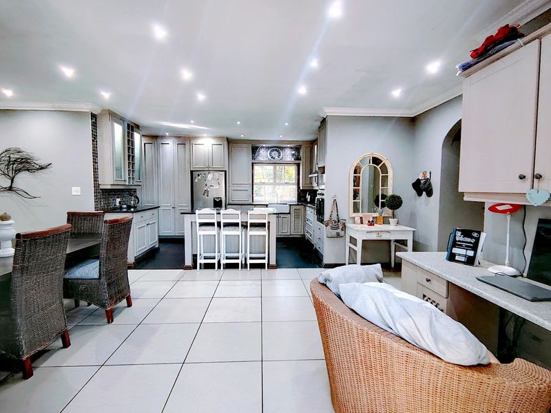 Spacious open-plan kitchen and living area featuring modern cabinetry, a central island, recessed lighting, and tiled flooring throughout.