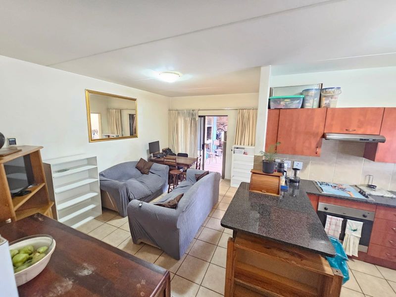 Open-plan living area featuring a kitchen with granite countertops, built-in oven, and extractor fan, seamlessly flowing into the lounge and dining space.