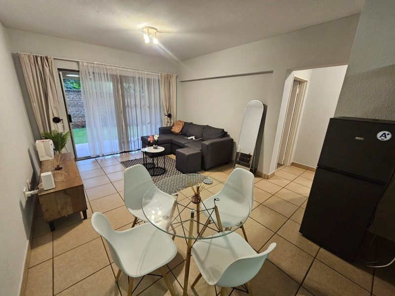 Open plan living and dining area featuring tiled flooring and a sliding glass door providing access to the outdoor space.
