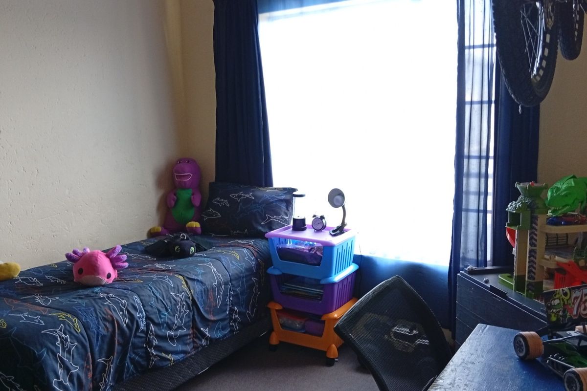 A standard bedroom featuring a large window with curtains, providing natural light and a functional space for a bedroom setup.