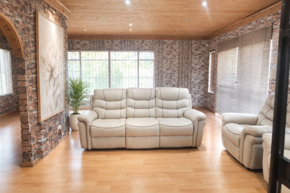 Spacious living room featuring exposed brick wall finishes, warm timber ceiling, and laminate flooring, creating a rustic and inviting atmosphere.
