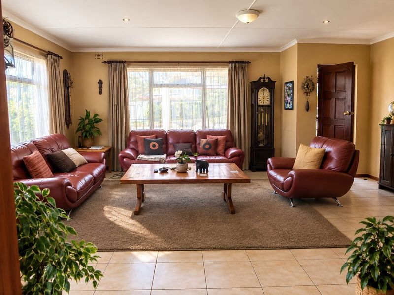 A spacious living room featuring neutral tiled flooring, recessed lighting, and large windows that provide ample natural light.