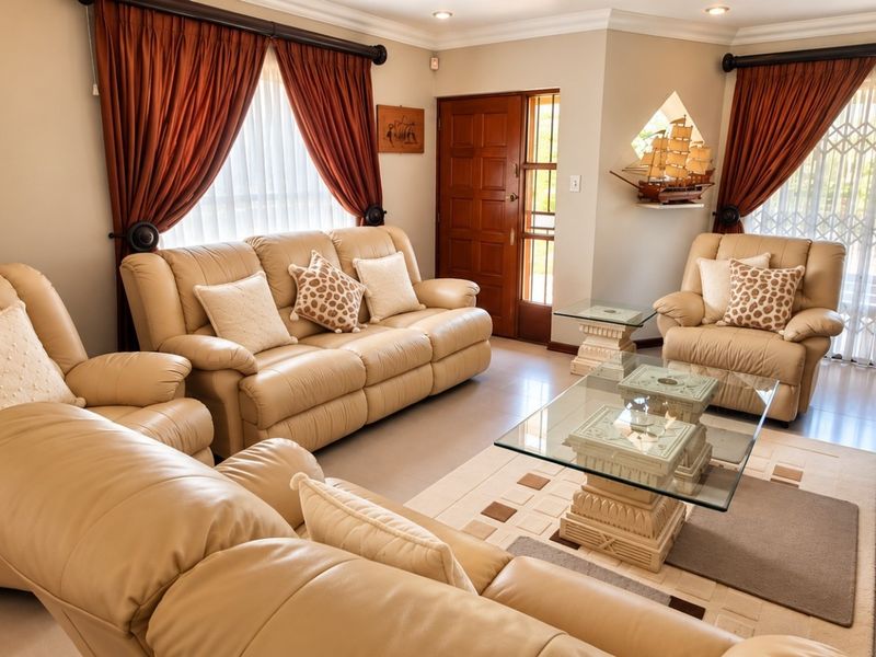 A well-maintained living room featuring tiled flooring, recessed downlighting, and decorative cove molding, providing a comfortable and functional space.