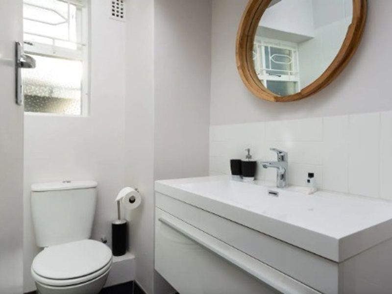 A modern, well-maintained bathroom featuring a sleek wall-mounted vanity with a chrome mixer tap and a standard toilet.