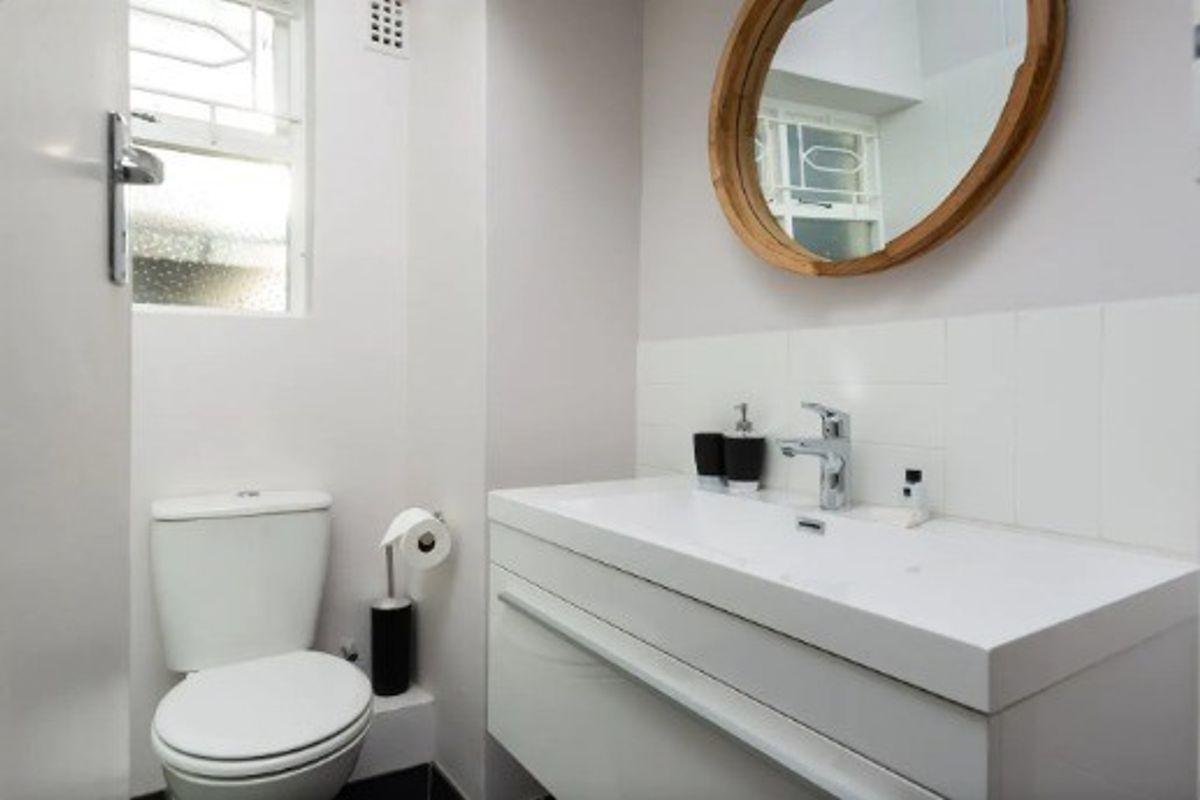 A modern, well-maintained bathroom featuring a sleek wall-mounted vanity with a chrome mixer tap and a standard toilet.