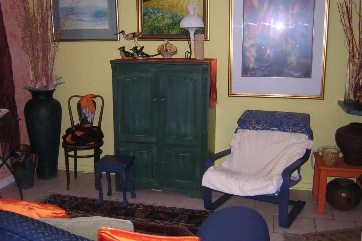 A living room area featuring tiled flooring and yellow painted walls.
