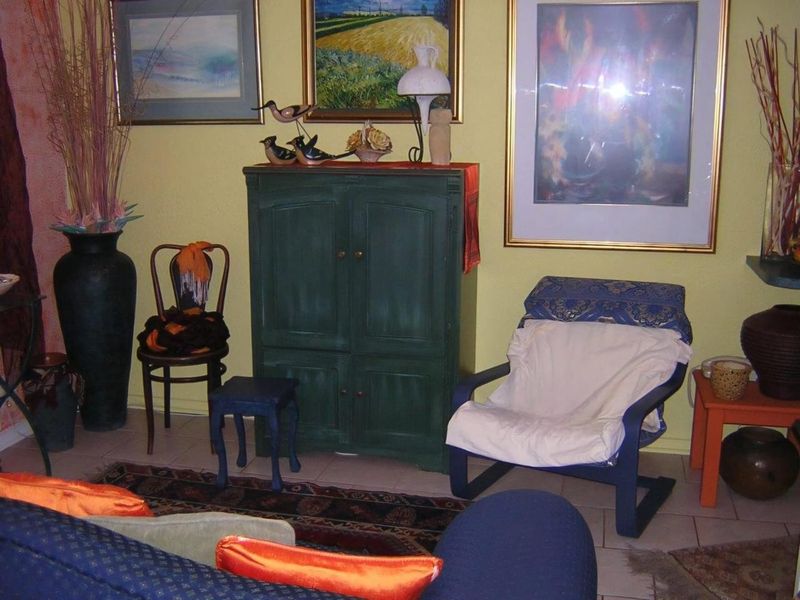 A living room area featuring tiled flooring and yellow painted walls.