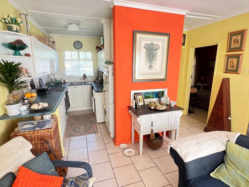 Open plan living and kitchen area featuring tiled flooring, built-in cabinetry, and a functional layout connecting the kitchen to the main living space.