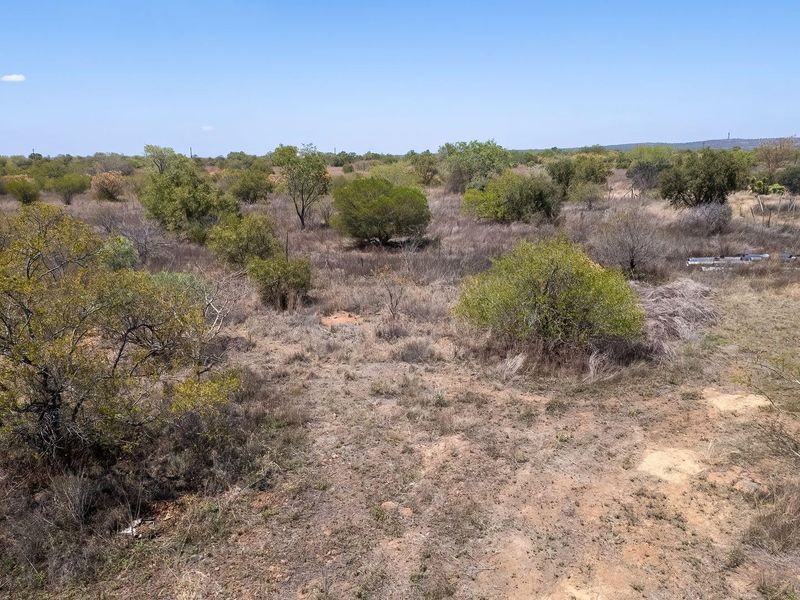 An elevated view of the expansive, undeveloped farm land featuring natural bushveld vegetation and open terrain.