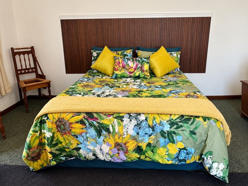A bedroom featuring a decorative timber slat headboard panel, providing a warm focal point for the sleeping area.
