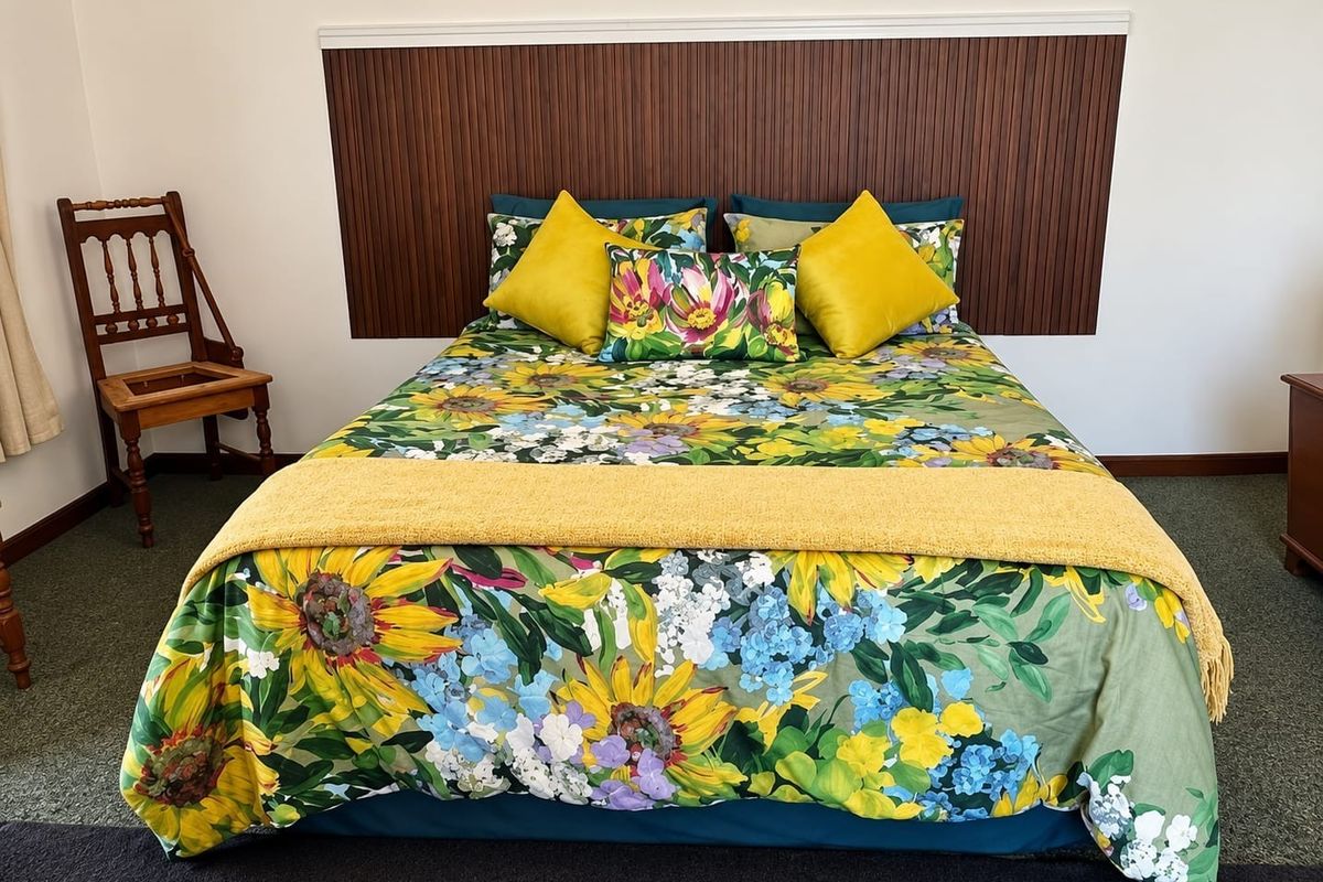 A bedroom featuring a decorative timber slat headboard panel, providing a warm focal point for the sleeping area.