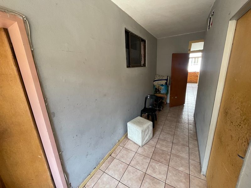 A functional hallway featuring tiled flooring and neutral wall finishes, providing access to adjacent rooms within the apartment.
