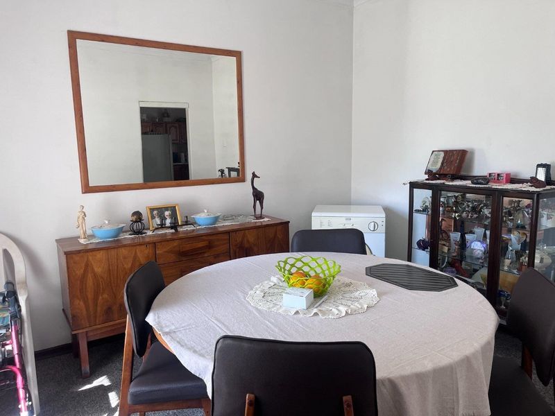 A dining room featuring carpet flooring and neutral wall finishes, providing a functional space for meals.