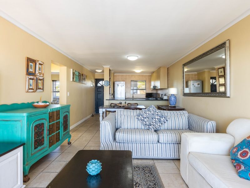 Open plan living and kitchen area featuring tiled flooring and functional cabinetry, offering a versatile space for daily living and dining.