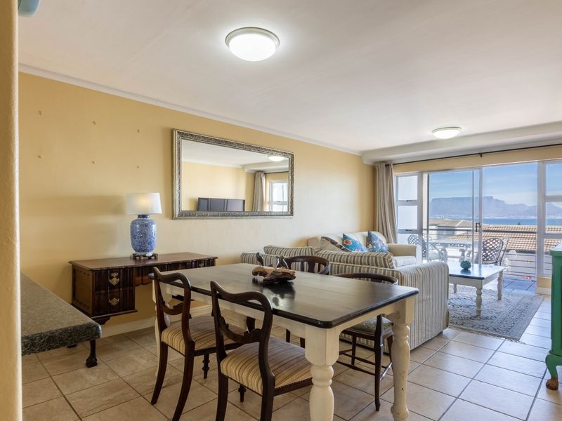 Open plan living and dining area featuring tiled flooring and large sliding glass doors that provide natural light and access to the balcony.