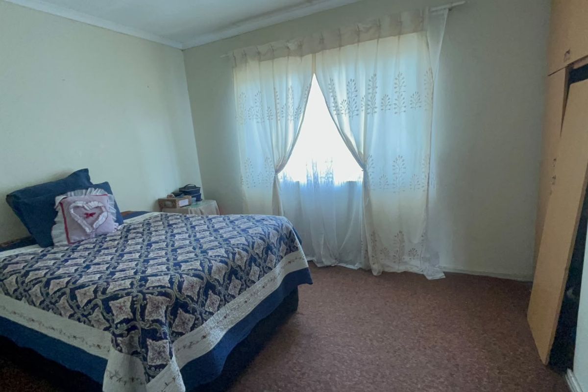 A functional bedroom featuring carpet flooring and a built-in wardrobe, offering a neutral canvas for potential updates.