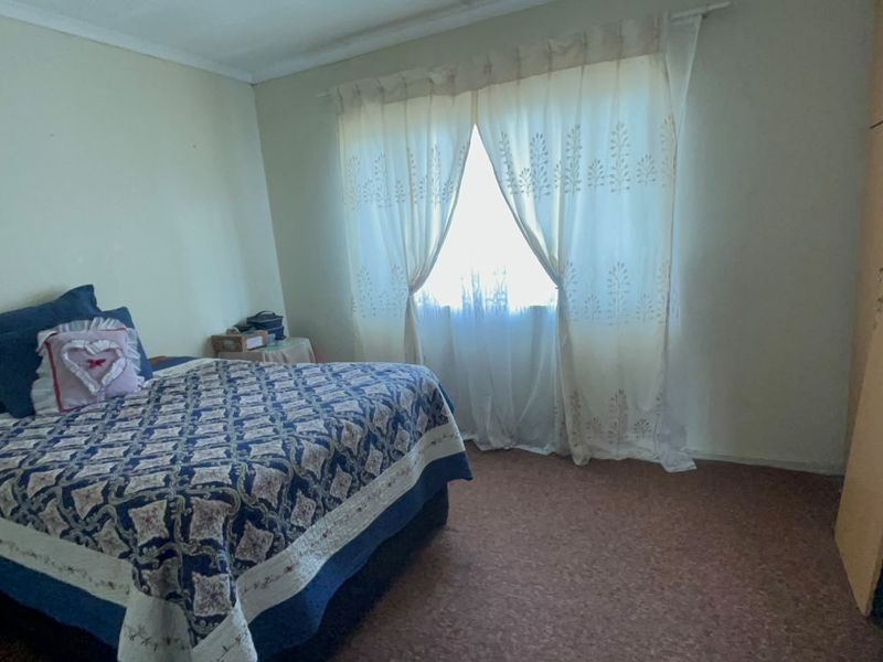 A functional bedroom featuring carpet flooring and a built-in wardrobe, offering a neutral canvas for potential updates.