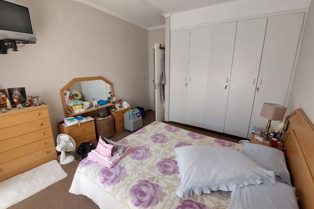 A functional bedroom featuring built-in cupboards and carpeted flooring, offering a neutral base for potential updates.