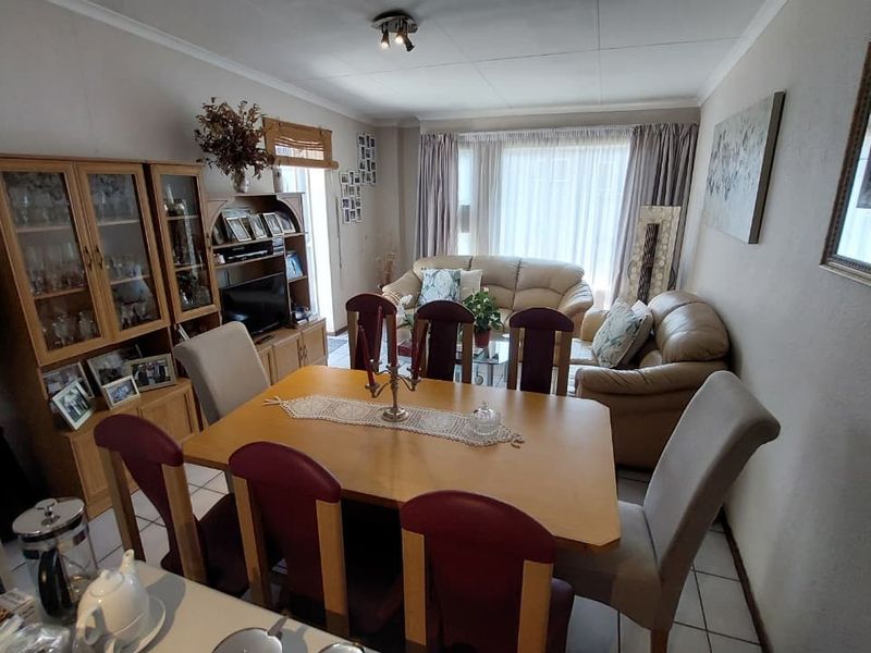 An open-plan living and dining area featuring tiled flooring and neutral wall finishes, providing a functional space for daily living and entertaining.
