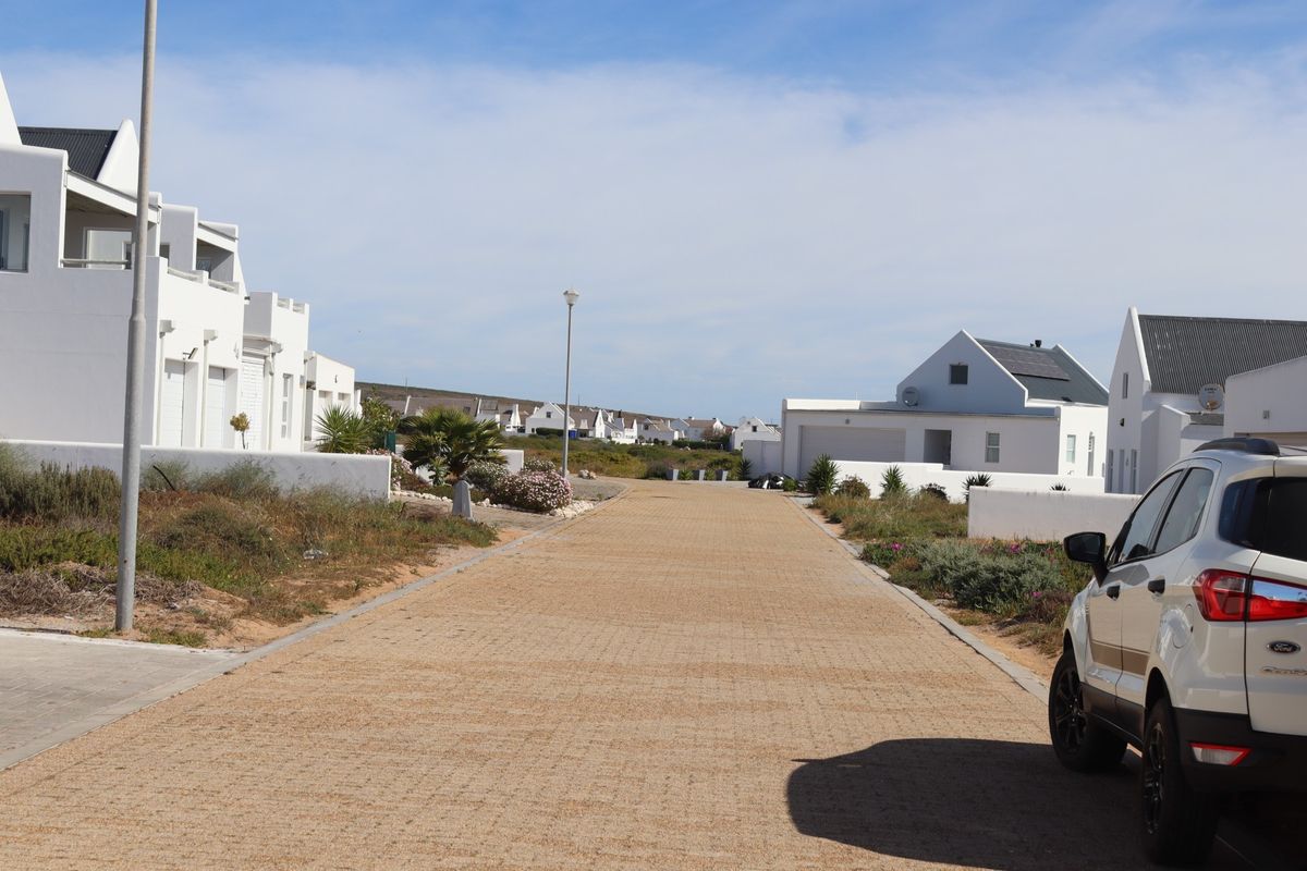 A view of the paved residential street and surrounding coastal-style homes within the estate.