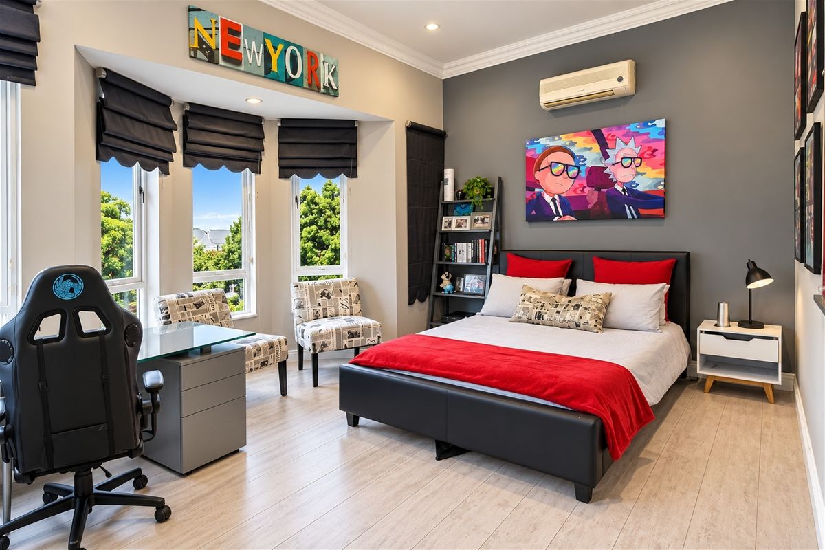 A well-maintained bedroom featuring laminate flooring, a bay window, recessed downlighting, and a wall-mounted split-system air conditioner.