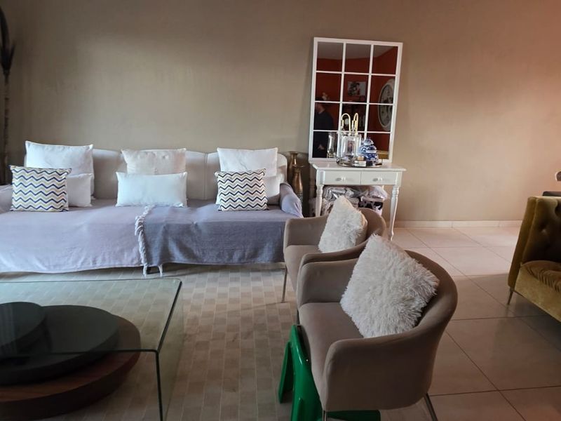 A comfortable living room featuring tiled flooring and a large sliding glass door providing access to the outdoor area.