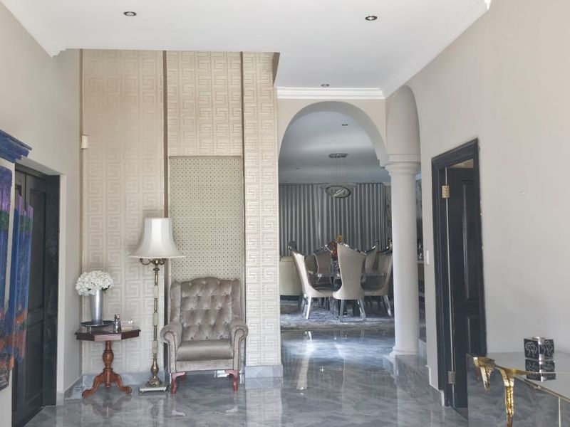 Spacious entrance hallway featuring polished marble flooring, decorative wall paneling, and an elegant archway leading into the main living area.
