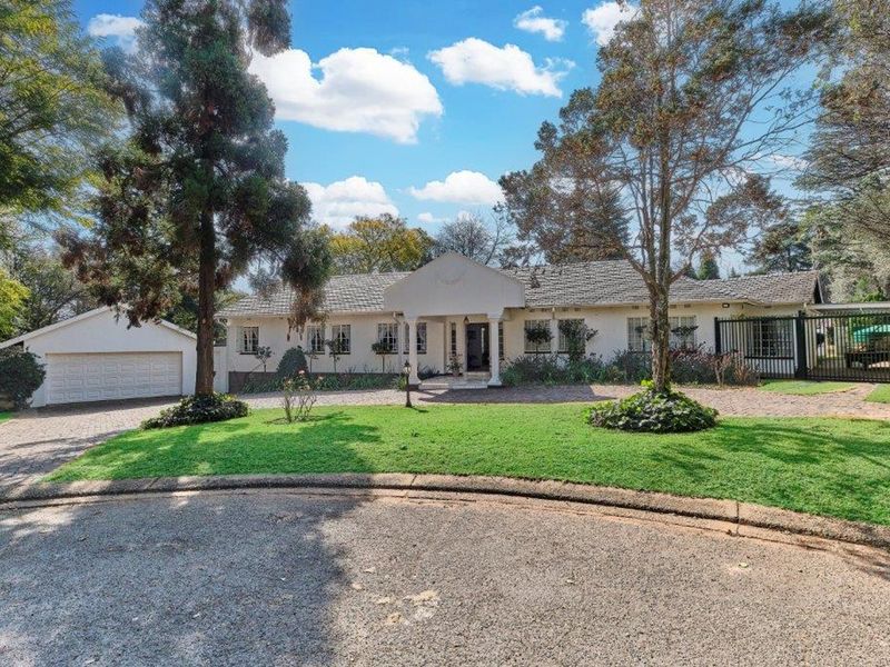 A well-maintained single-story residence featuring a paved driveway, attached garage, covered entrance portico, and established garden in a quiet suburban setting.